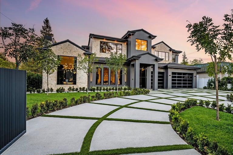 Modern luxury home exterior with manicured lawn and geometric driveway